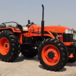A bright orange ACE DI 65 4WD tractor showcased outdoors in Faridabad, India.